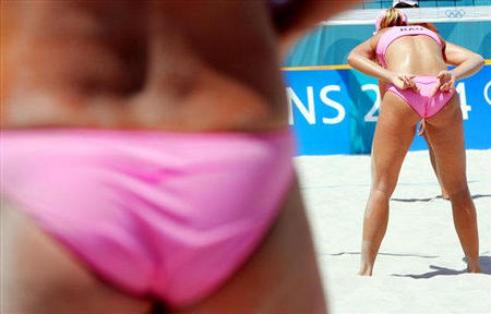 Germany's Okka Rau, right, hides her hands behind her back as she sends a signal to her partner Stephanie Pohl, left, during their match at the Olympic Beach Volleyball Centre, Athens, Greece, August 14, 2004.